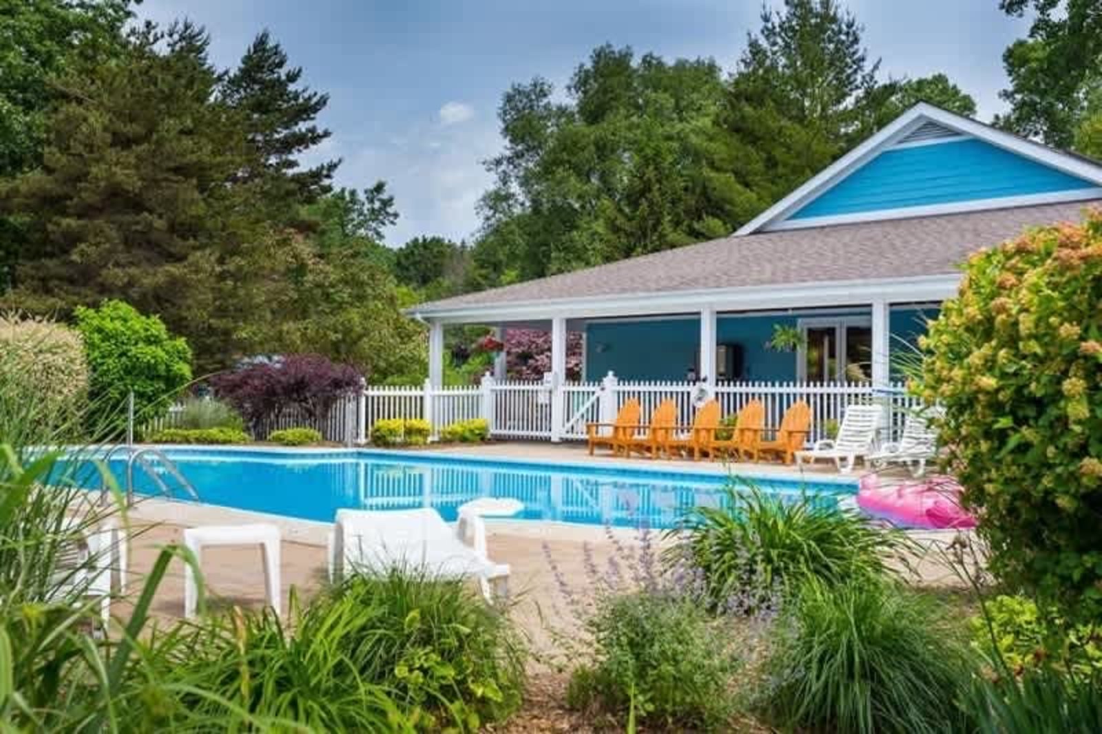 Blue Haven’s community marina pool with lounge chairs and a blue clubhouse